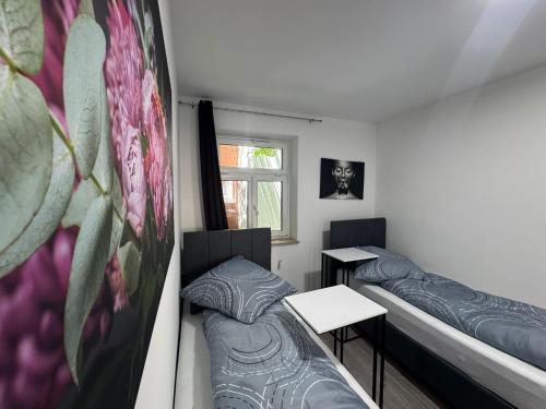 two beds in a room with two tables and a window at Apartments in Nürnberg