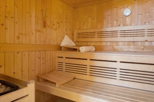 a wooden sauna with a bench and a clock at Chalet Am Ried in Bad Wurzach