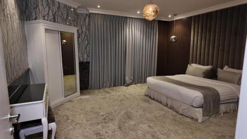 a bedroom with a large bed and a television at إيلاف الدمام للوحدات السكنية المخدومة in Dammam