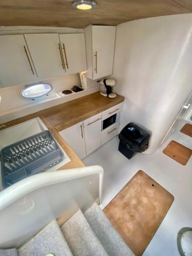 une petite cuisine avec des armoires blanches et un évier dans l'établissement BOAT PARADISE LA ROCHELLE - Cranchi Méditerranée 40, à La Rochelle