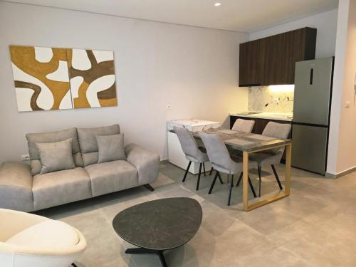 ein Wohnzimmer mit Couch und Tisch und eine Küche in der Unterkunft Blue Harmony in Lalzit Bay