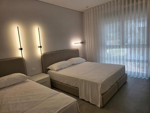 ein Hotelzimmer mit zwei Betten und einem Fenster in der Unterkunft Blue Harmony in Lalzit Bay