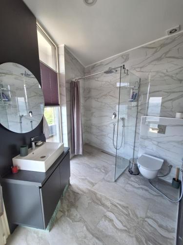 a bathroom with a sink and a shower and a toilet at Skyline sea view apartment in Bečići