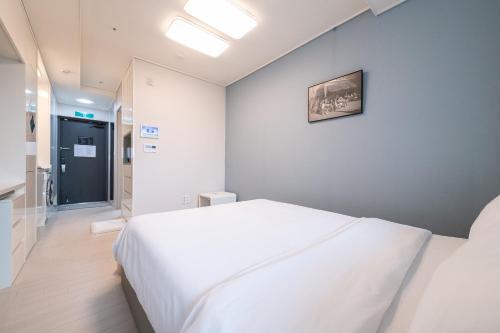 a bedroom with a white bed with a picture on the wall at The November Stay In landmark in Incheon