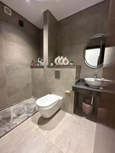 a bathroom with a toilet and a sink at شقة فندقية بالشيخ زايد Zed residense in Cairo