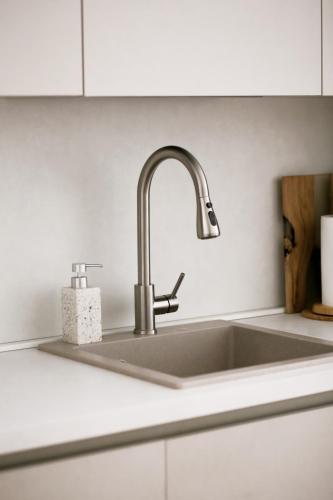 a stainless steel sink in a white kitchen at Valeri Lux Becici in Rafailovici