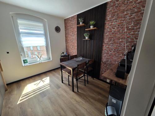 a dining room with a table and a brick wall at Haus Kabelitz in Kabelitz