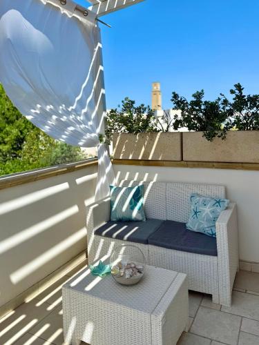 a porch with a chair and a table on a balcony at Dimora Il Girasole in Torre San Giovanni Ugento