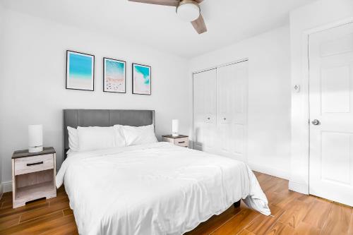 a white bedroom with a large bed and two night stands at The Coastal Dream! Only 3miles to the beach, Fast WiFi, Garage in Naples