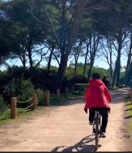 a person in a red coat riding a bike down a dirt road at Cosy Apartment Near Beach & Airport in Tangier