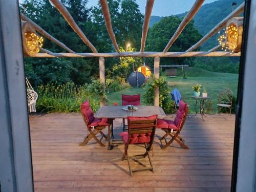 a patio with a wooden table and chairs at La rosa sul lago in Osiglia