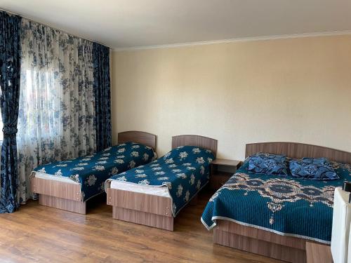 Un dormitorio con dos camas y una ventana en Edelweiss 1, en Cholpon-Ata