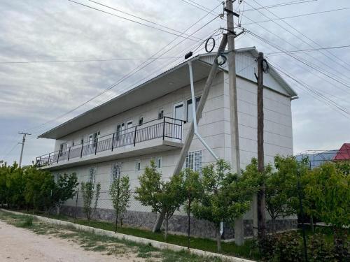 Un edificio blanco con un balcón al costado. en Edelweiss 1, en Cholpon-Ata