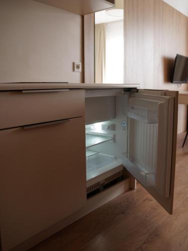 an empty kitchen with an open refrigerator at Warsoliv double in Warsaw