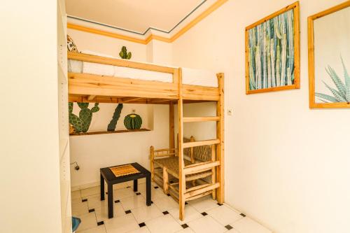 a room with a bunk bed and a table at Ifni Surf Hostal in Sidi Ifni