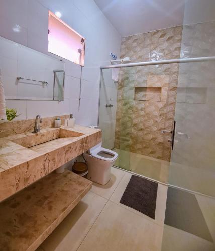 a bathroom with a shower and a sink and a toilet at POUSADA MANACÁ DA SERRA in Vargem Bonita