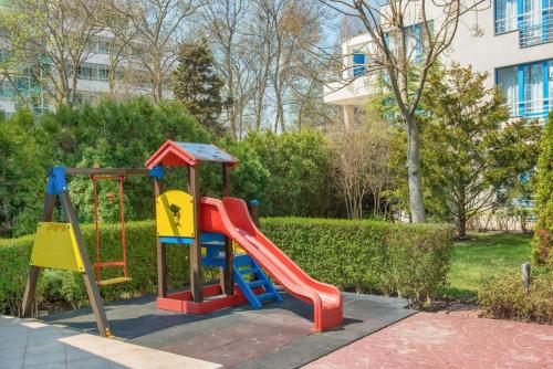 a playground with a slide in a park at Excelsior Prince ApartHotel in Sunny Beach