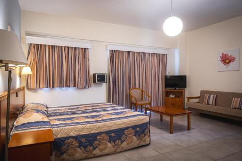 a hotel room with a bed and a couch at Kefalos Damon Hotel Apartments in Paphos City