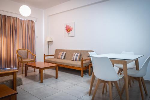 a living room with a couch and a table at Kefalos Damon Hotel Apartments in Paphos City