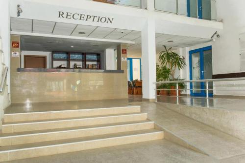 a lobby of a building with stairs and a reception at Excelsior Prince ApartHotel in Sunny Beach