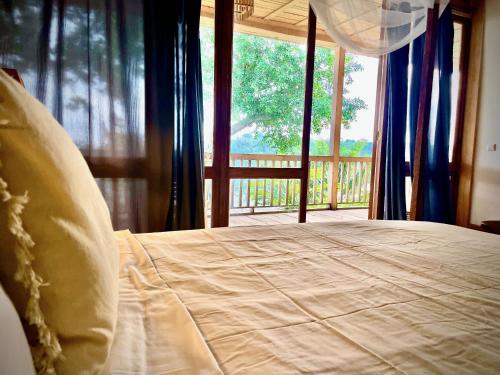 a bedroom with a bed with a view of a porch at Casa do Mar in São Tomé