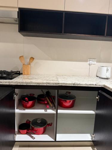 a kitchen counter with red pots and pans at 3403!Dubai SkyLine View! Royal Montania Homes in Dubai