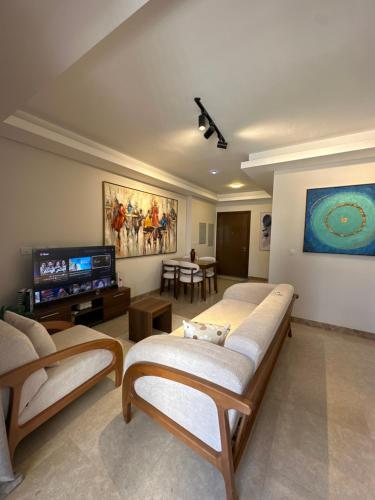 a living room with couches and a flat screen tv at شقة فندقية بالشيخ زايد Zed residense in Cairo