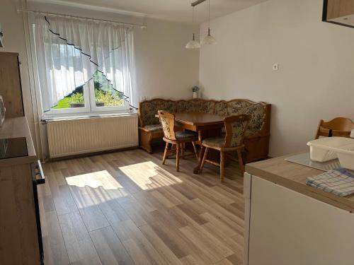 a kitchen and living room with a table and chairs at Apartma Rekar - a house, where you can relax in the embrace of nature in Jesenice