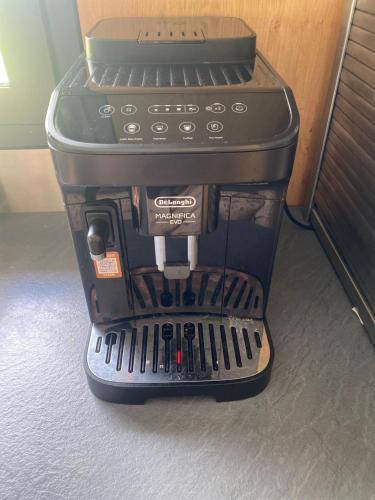 a black coffee maker sitting on top of a table at La maison normande in Rots