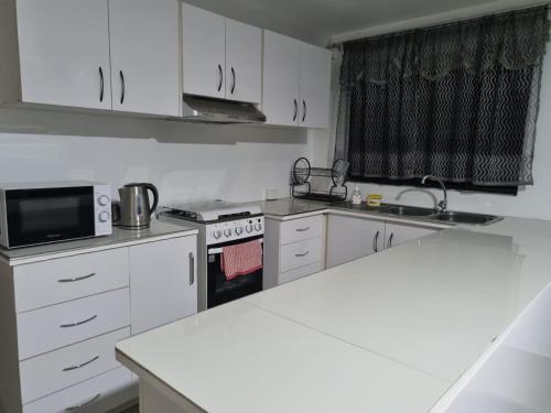 a kitchen with white cabinets and a white counter top at Bula Breeze in Nadi