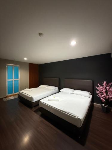 two beds in a hotel room with flowers on the wall at 1st Living Subang SS15 in Subang Jaya