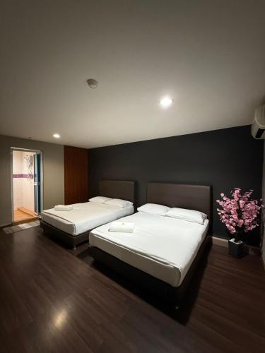 two beds in a hotel room with flowers on the wall at 1st Living Subang SS15 in Subang Jaya