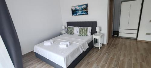 a bedroom with a bed with white sheets and a wooden floor at INDRA WELLNESS Retreats and Spa in Samurcaşi