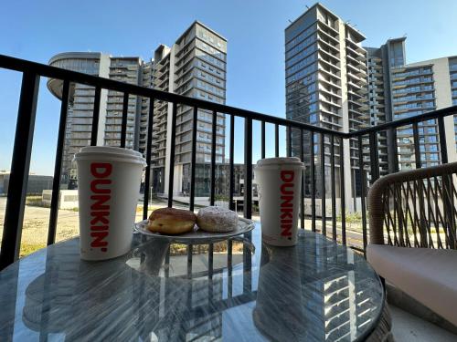a table with two cups and donuts on a balcony at شقة فندقية بالشيخ زايد Zed residense in Cairo