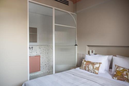 ein Schlafzimmer mit einem Bett mit weißen Laken und Kissen in der Unterkunft Suite luxe-spacieux Ben Yehouda in Jerusalem