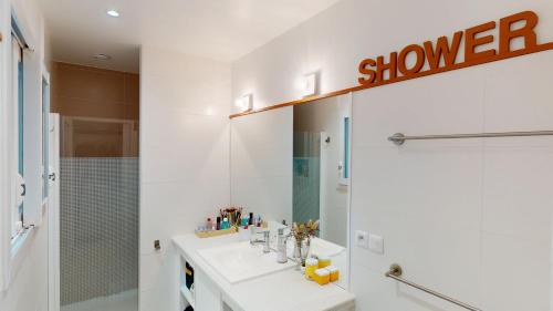 une salle de bain blanche avec un lavabo et une douche dans l'établissement Maison tout confort à Angresse, à Angresse