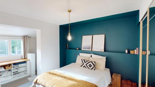 - une chambre avec un mur bleu et un lit dans l'établissement Maison tout confort à Angresse, à Angresse