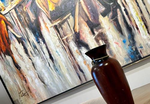a vase sitting on a table in front of a painting at شقة فندقية بالشيخ زايد Zed residense in Cairo