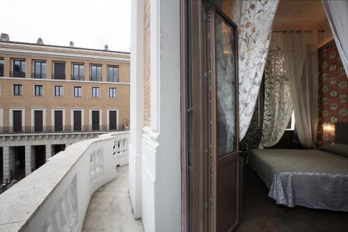 a room with a balcony with a bed and a window at Antica Dimora Delle Cinque Lune in Rome