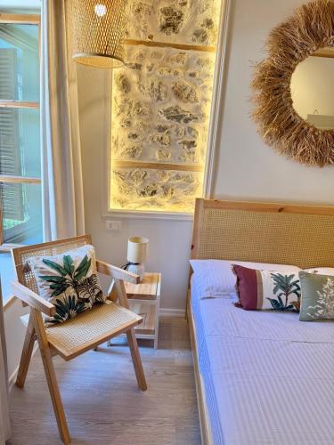 a bedroom with a bed and a chair and a mirror at Old Town Suites Muradie in Vlorë