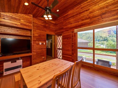 a wooden dining room with a table and a tv at LiVEMAX RESORT Hakodate Greenpia Onuma in Mori
