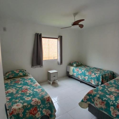 a room with two beds and a window at Aconchegante Casa em Gravatá - Casa 10 in Gravatá