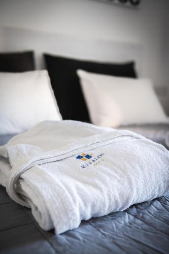 a white towel sitting on top of a bed at Kefalos Damon Hotel Apartments in Paphos City