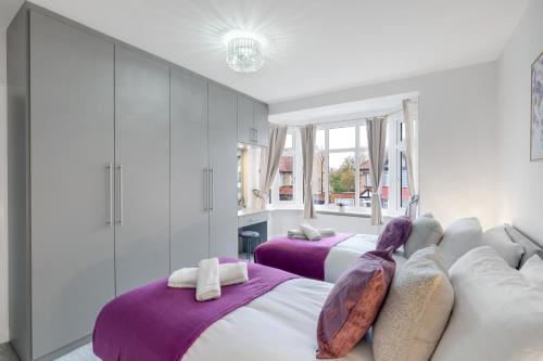 two beds in a bedroom with purple and white at Stylish 3BR House Close to Wembley Stadium and Arena in London