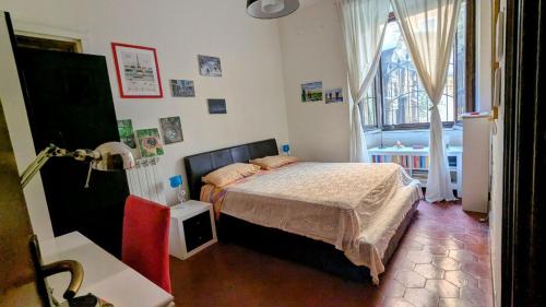 una camera da letto con un letto e una finestra di Cozy room in Piazza Vittorio a Roma