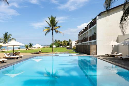 a swimming pool in front of a resort at EKHO Surf Bentota in Bentota