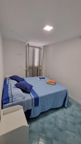 ein Schlafzimmer mit einem Bett mit einer blauen Decke in der Unterkunft Villa Dei Santi, Azzurro in Santa Maria di Castellabate