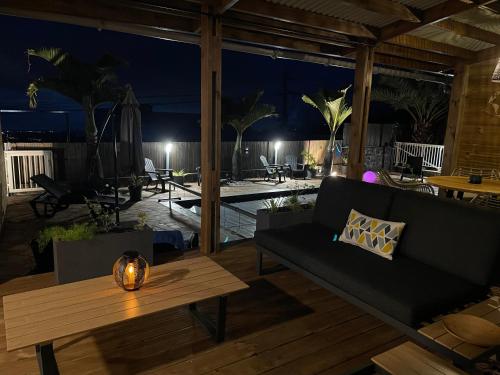 a living room with a couch and a table at Harmonie de 3 logements- Villa des 4 Sens in Le Tampon