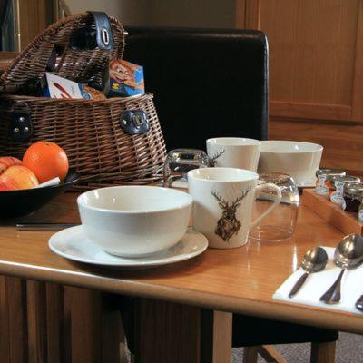 a table with bowls and cups and a basket of fruit at Dovestays in Laxton