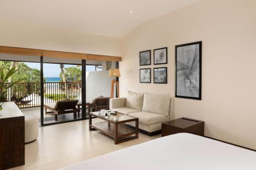 a living room with a couch and a table at EKHO Surf Bentota in Bentota